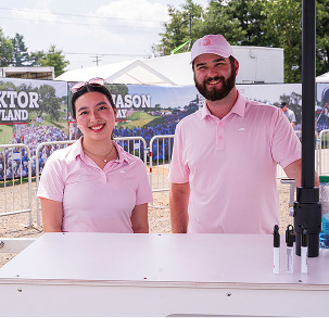 two employees staffing a table at Travelers Championship
